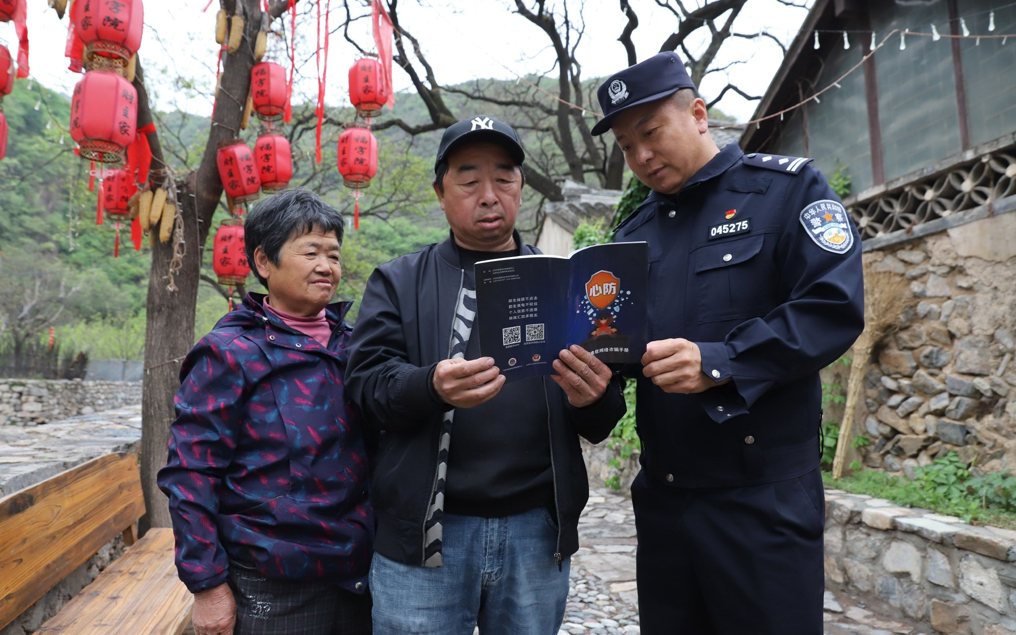 因為村里留守老人多，李英海（最右）組織社區民警挨家挨戶上門，手把手為村民安裝反詐App。 圖源：北京市公安局