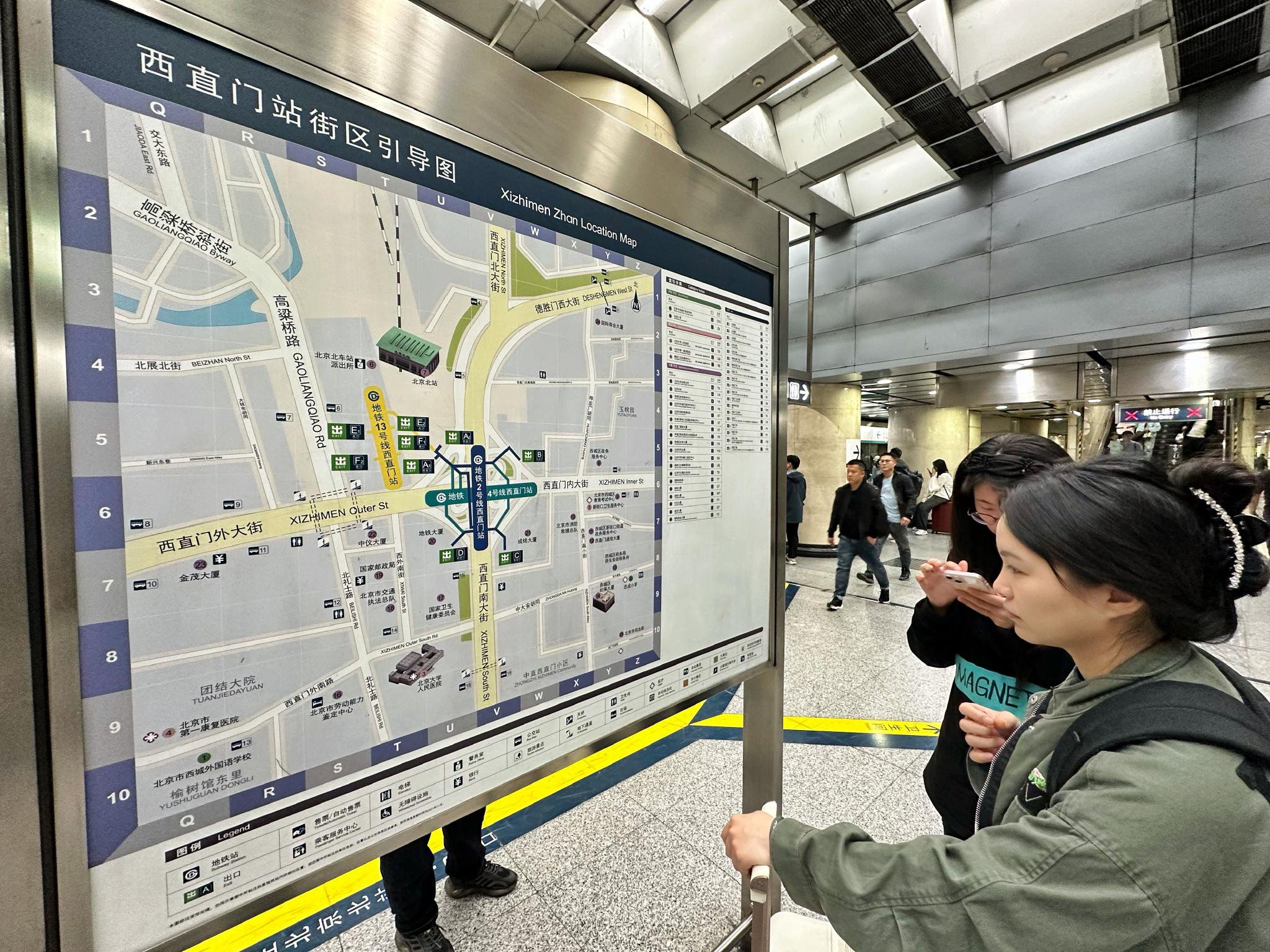 地鐵西直門站一共有九個出入口，5月6日中午，一名乘客正在查看出入口地圖信息。新京報記者 裴劍飛 攝