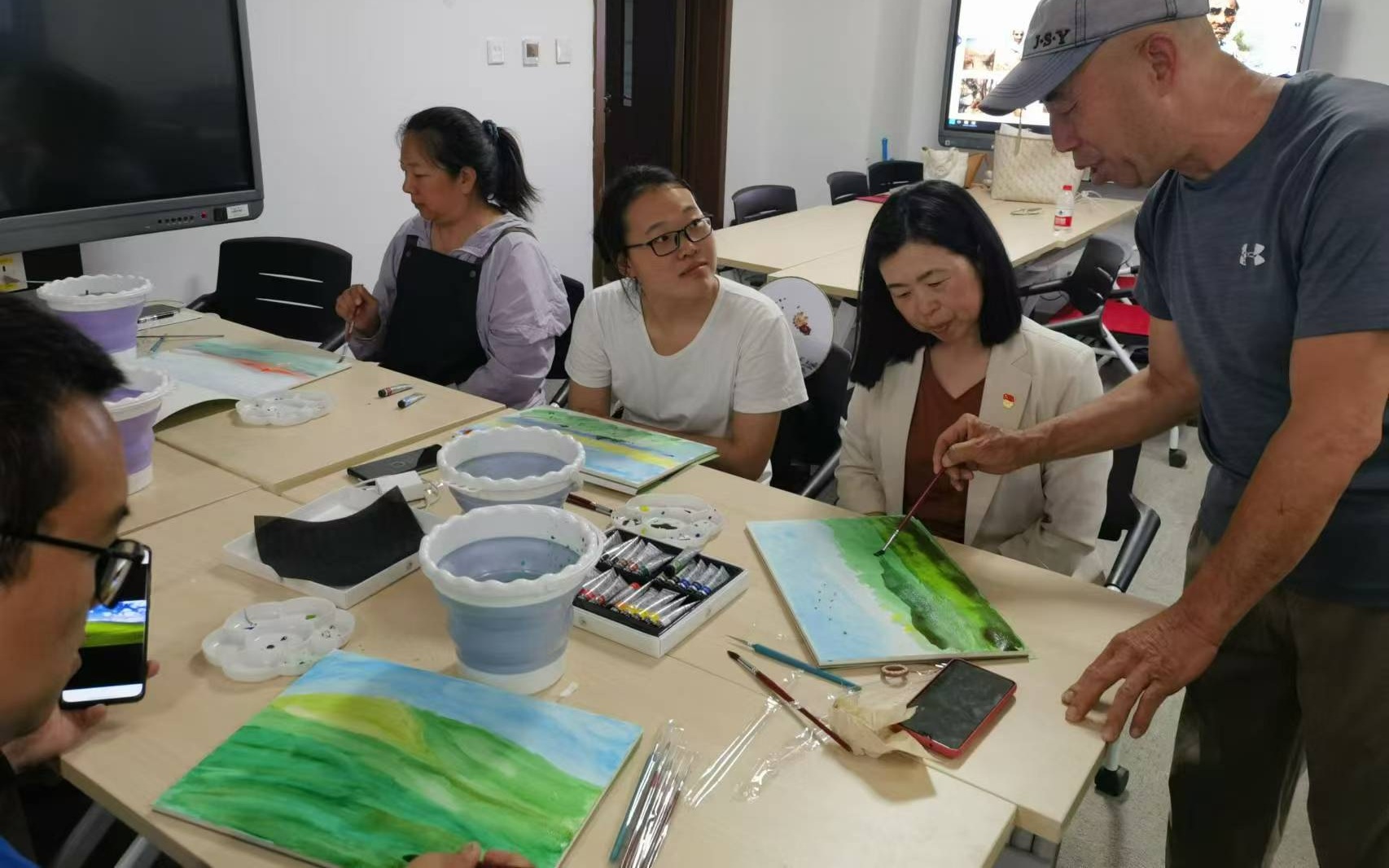 黃金龍為學生修改作品,並講解水彩畫中輕重色彩的使用。新京報記者 楊菲菲 攝