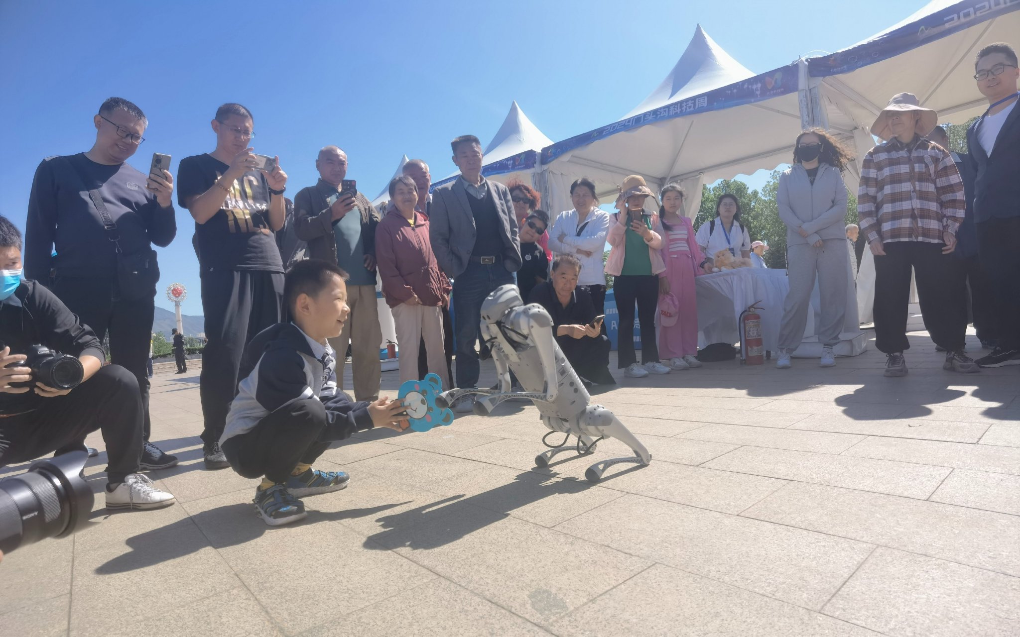 活動現場，小朋友正在與機器狗互動。新京報記者 周懷宗 攝