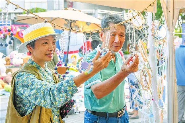 在海口复兴城互联网信息产业园,市民在市集上挑选手工艺品。记者 孙士杰 摄