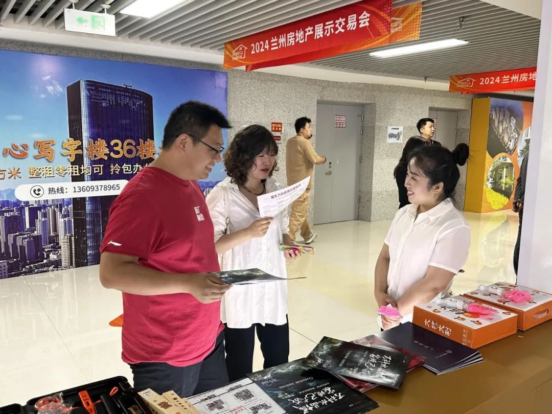 图为展区内销售人员向顾客介绍房型