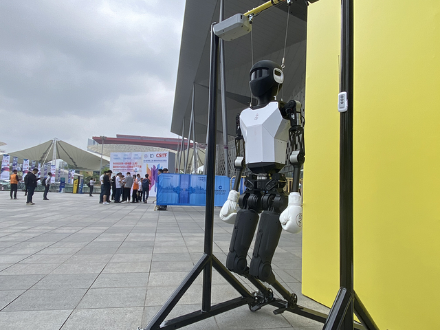 在入館人流中,照片中的雙足人形機器人完成了從世博展覽館北廣場“步行”到H1館展台的參展之旅。澎湃新聞記者 俞凱 圖