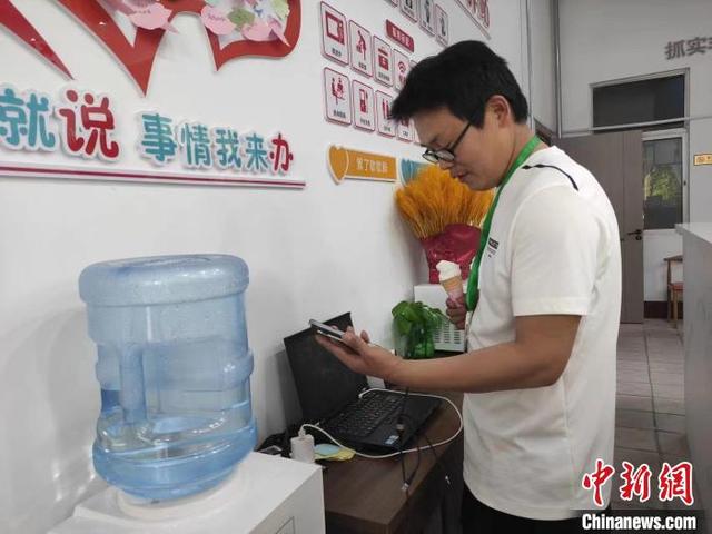 在泰安市寧陽縣文廟街道河濱社區黨群服務中心,戶外網絡維修勞動者在大廳為手機充電。(寧陽縣官方供圖)