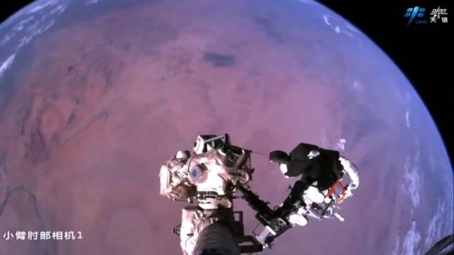 航天员站机械臂与地球同框