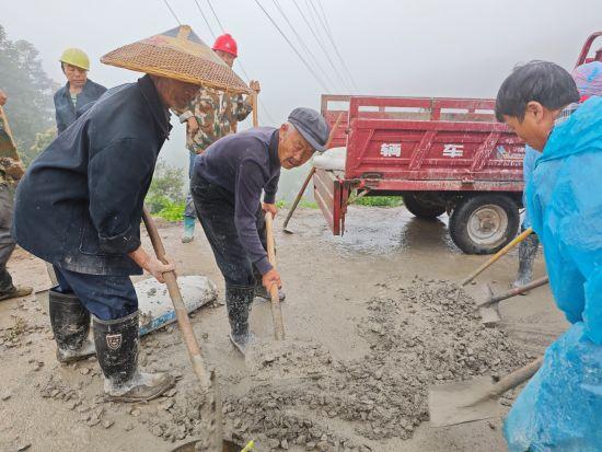 83歲的村民肖輝禮在和水泥。 陳健 攝