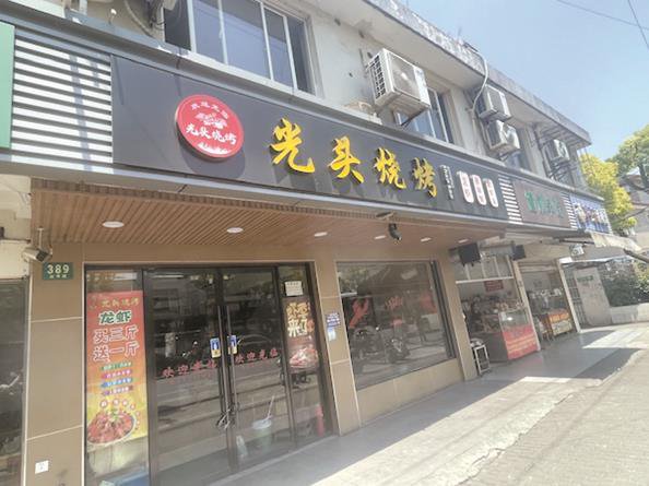 新育路油汙雨水井附近的餐飲店舖 本版攝影 夏韻