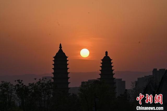 4月17日,山西省太原市,夕陽與百年古刹永祚寺雙塔相互映襯,現“雙塔落日”景觀。 中新社記者 韋亮 攝