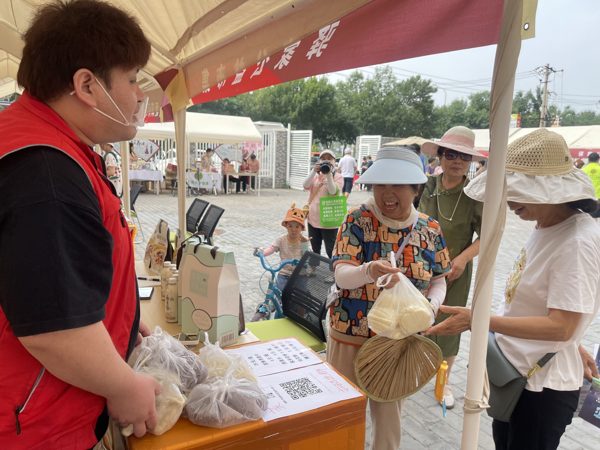 居民們在大集上選購養老餐桌廚師製作的花捲。新京報記者 吳婷婷 攝