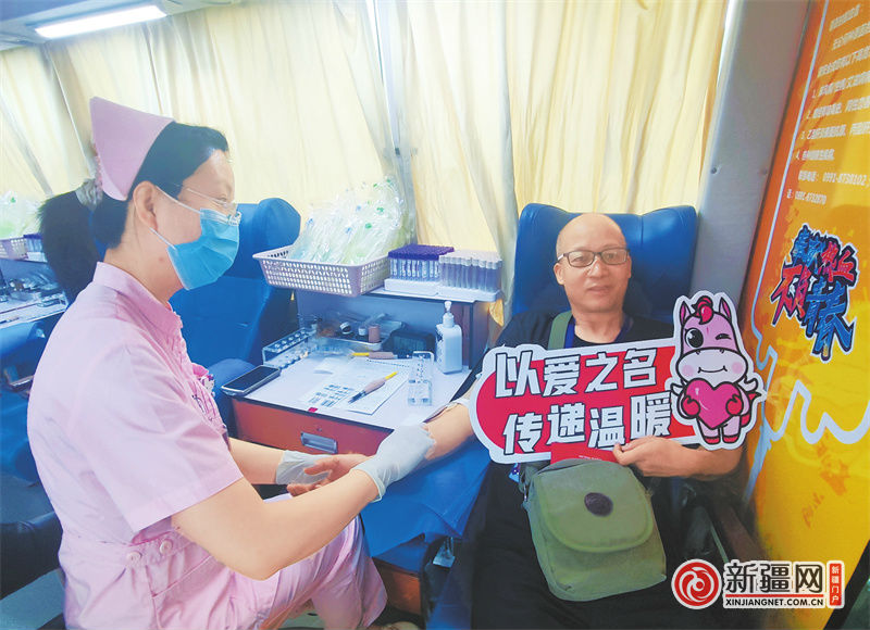 6月15日,在会展吾悦广场的一辆移动献血车上,市民许国平正在捐献血液,传递爱心。(全媒体记者李晓青摄)