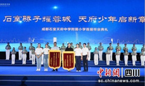 毕业典礼上学生家长代表为学校赠送锦旗。安源 摄