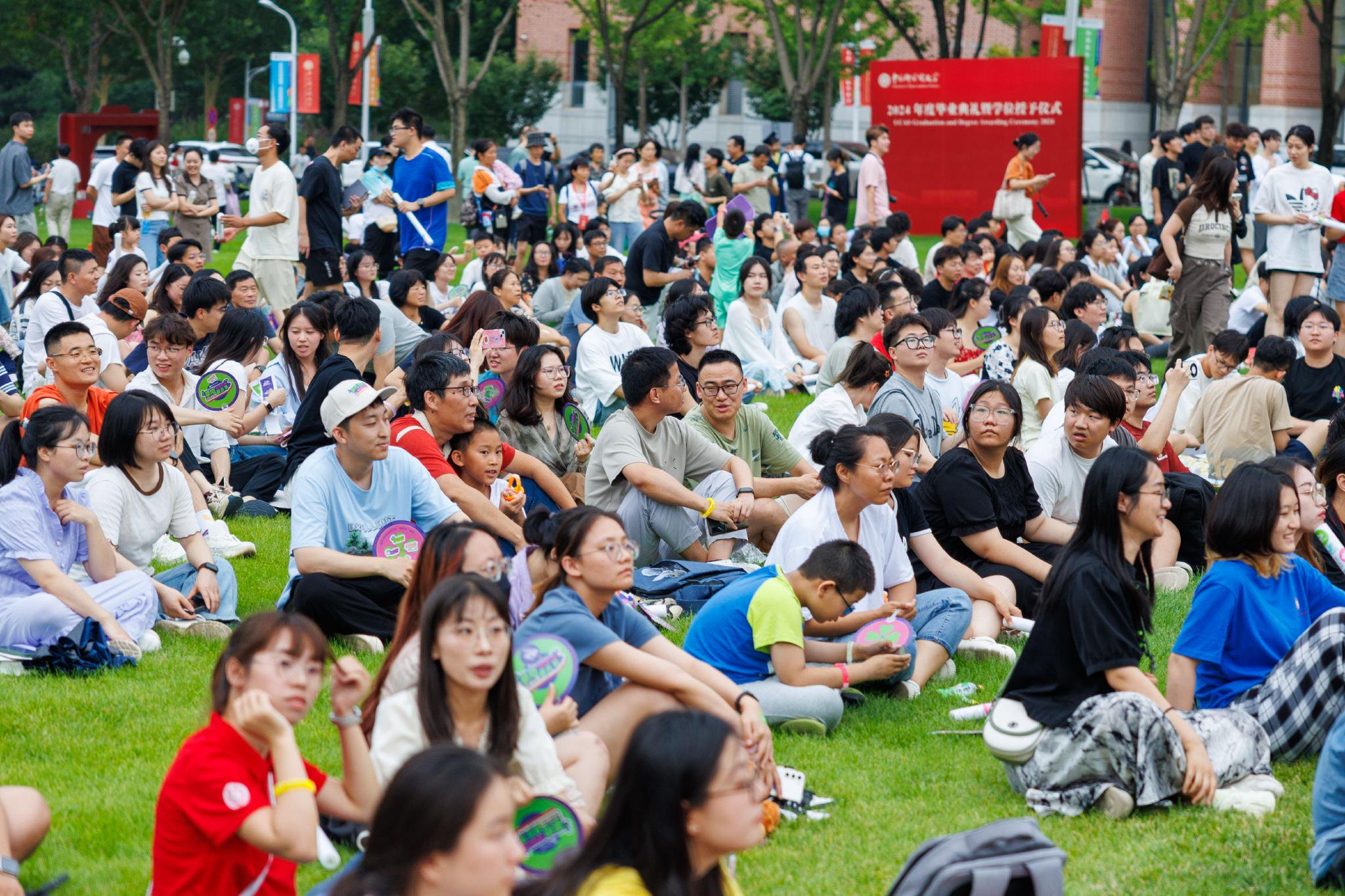 參加音樂節的師生和家長席地而坐，欣賞音樂。新京報記者 王子誠 攝