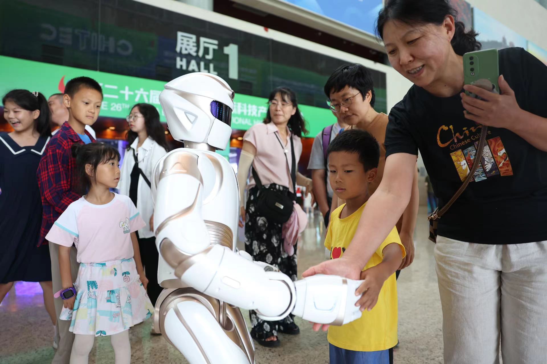 家長和孩子們與機器人握手感受其握力。新京報記者 王飛 攝