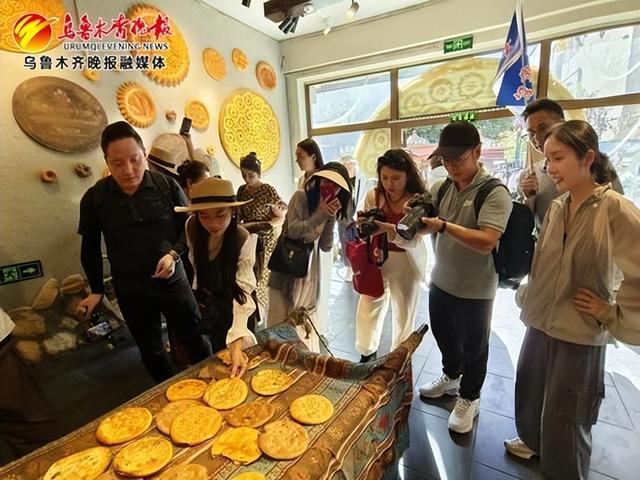 7月14日,在国际大巴扎,采访团记者正在拍摄新疆馕。记者唐红梅摄