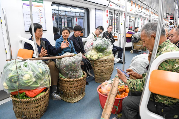 3月27日清晨,菜农乘坐重庆轨道交通4号线,准备前往城区的菜市场售卖农产品。新华社记者 王全超 摄