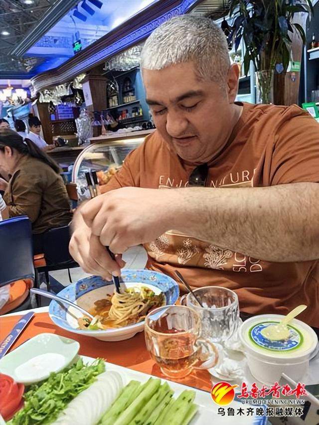 土库曼斯坦厨师穆拉特·奥洛正在品尝新疆美食过油肉拌面。乌鲁木齐饮食服务行业协会供图