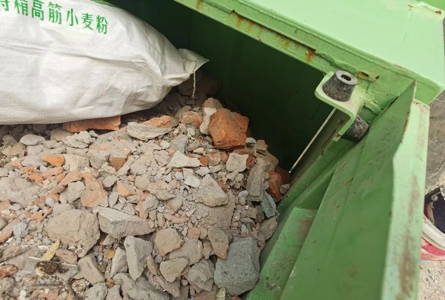 居民不放过箱子的每一个角落,将装修垃圾破袋后倒入共享收集箱,充分利用每一寸空间。 陈玺撼 摄
