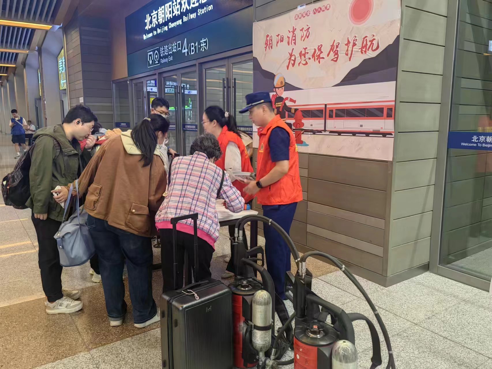 消防指戰員和車站工作人員為旅客發放紀念品。圖源:朝陽區消防救援支隊