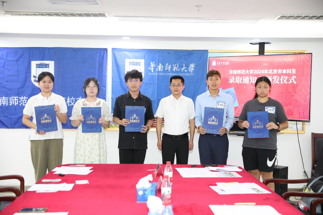 華南師範大學黨委副書記王岩(右三)為2024級本科新生們發放錄取通知書。學校供圖