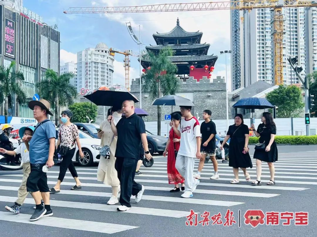 天气炎热,市民撑伞出行。