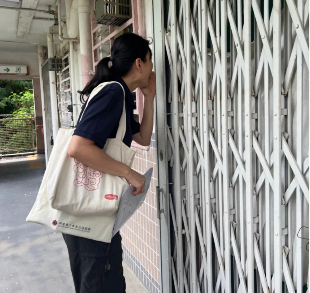 图 | 香港西环邨,明爱社工珊姑娘在听障长者家门口