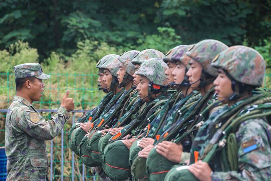     9月10日，空降兵某部官兵在傘塔下進行傘降訓練演示，骨幹對背傘情況進行檢查。肖豔飛/攝