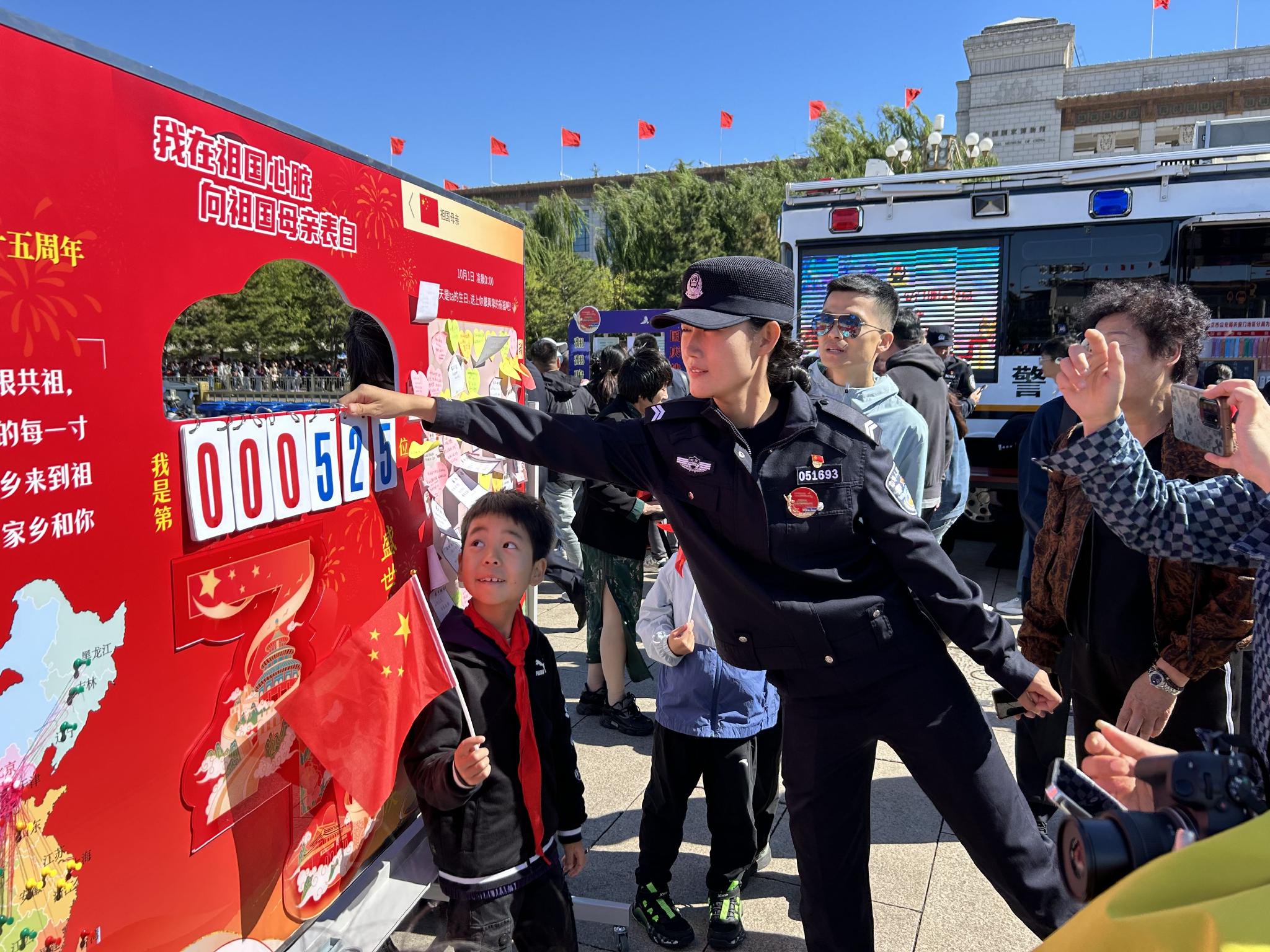 「為民服務車」執勤民警為遊客介紹「向祖國母親表白」展板。 新京報記者 彭鏡陶 攝