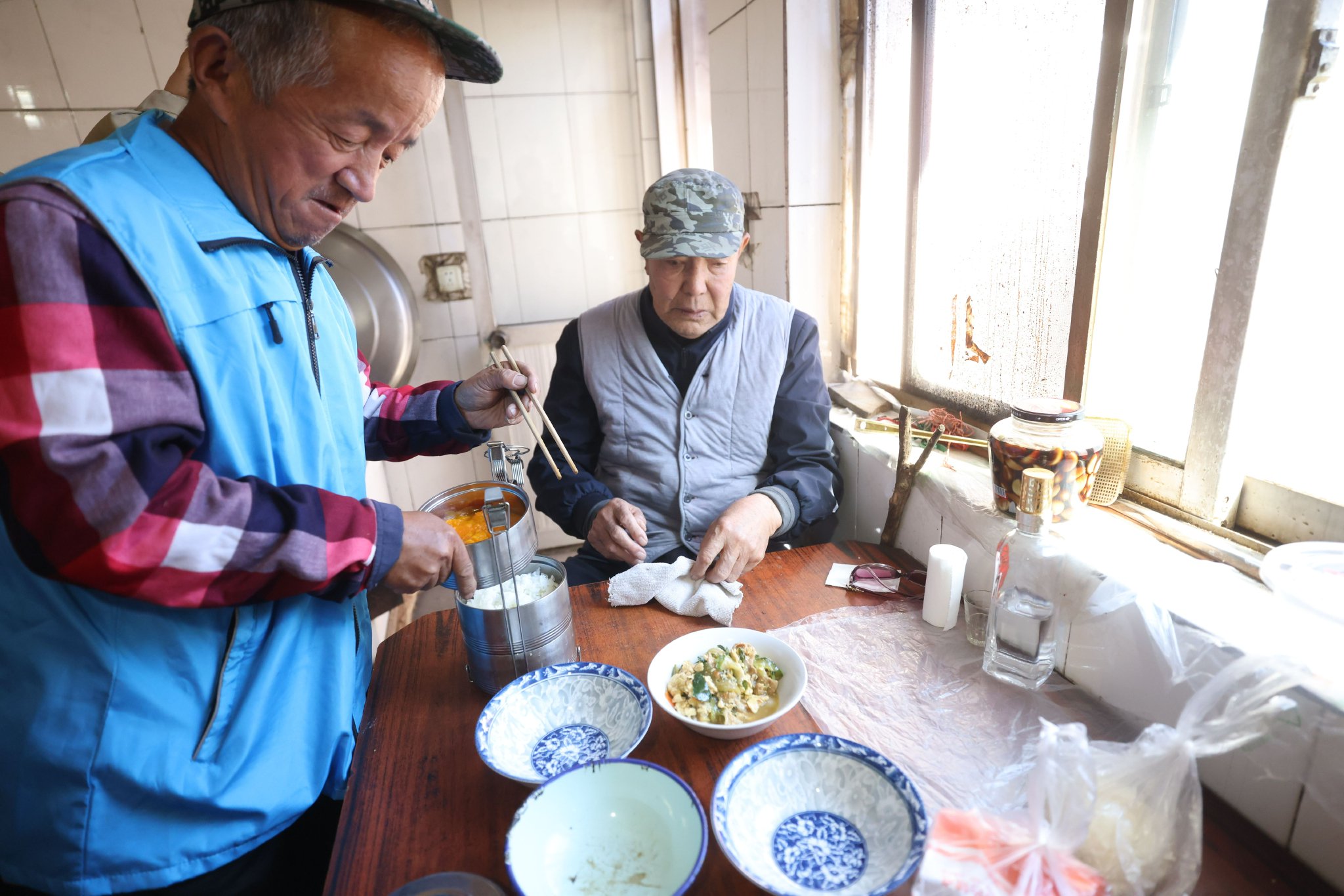 送餐員將老年餐擺放到餐桌上。新京報記者 王貴彬 攝