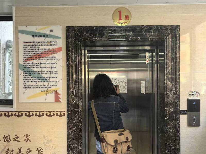 居民正在拍摄电梯里的画作