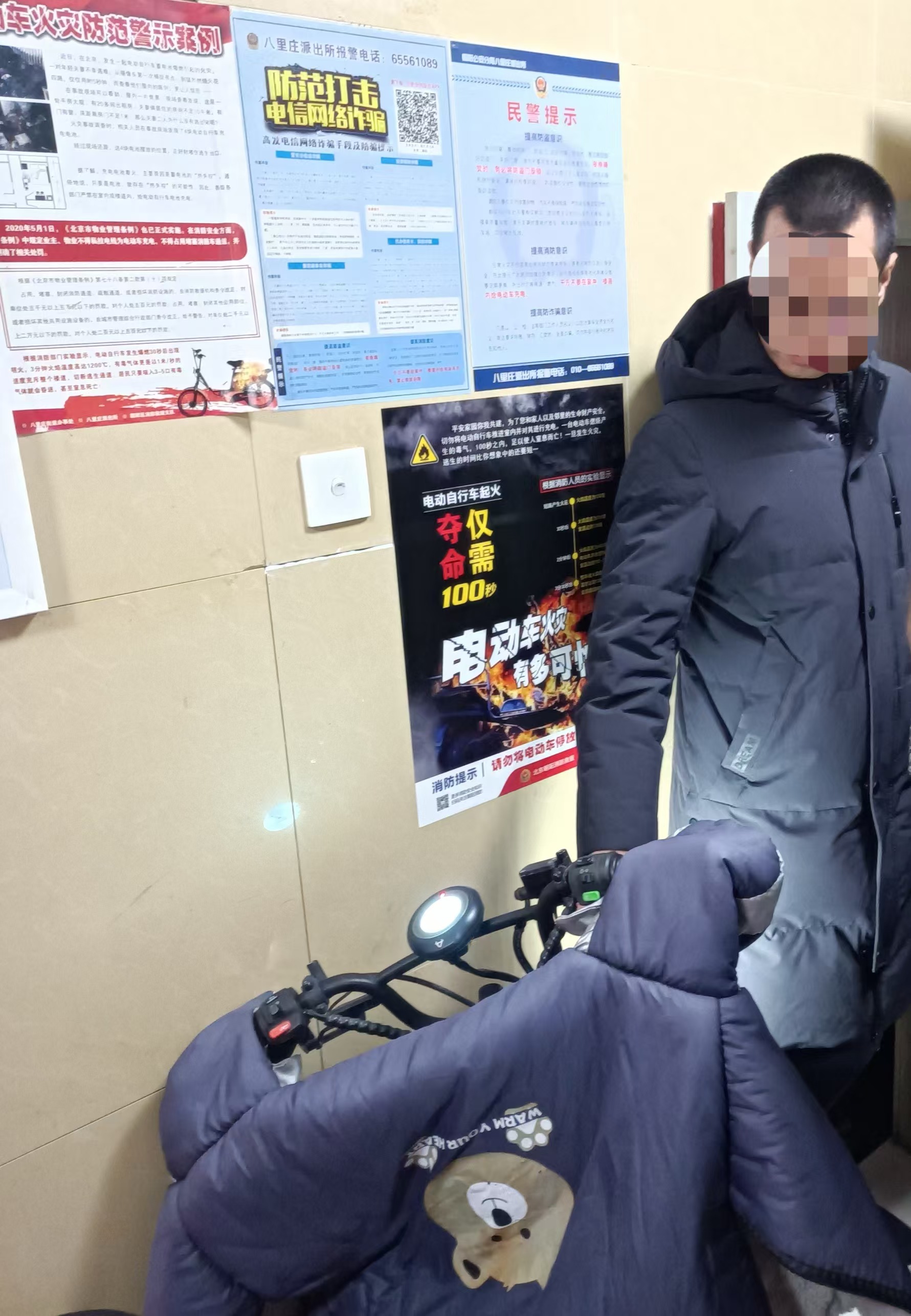 警示海報貼在牆上，電動單車停放在疏散通道內。實習生 武亮亮 攝