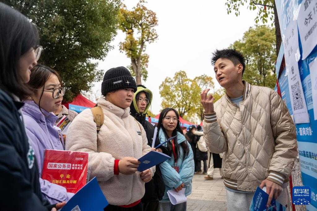 12月23日,在长沙师范学院举办的2025届毕业生冬季招聘会上,招聘人员(右一)向求职学生介绍岗位信息。