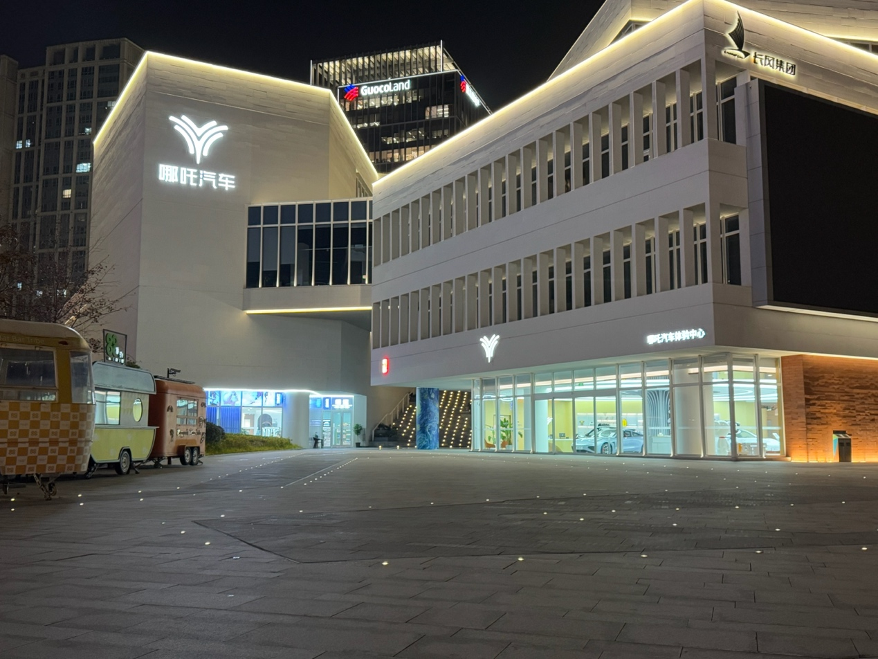 （图为12月17日晚8点，位于上海市普陀区的哪吒汽车总部大楼以及哪吒汽车全球旗舰体验中心。杨让晨/摄影）