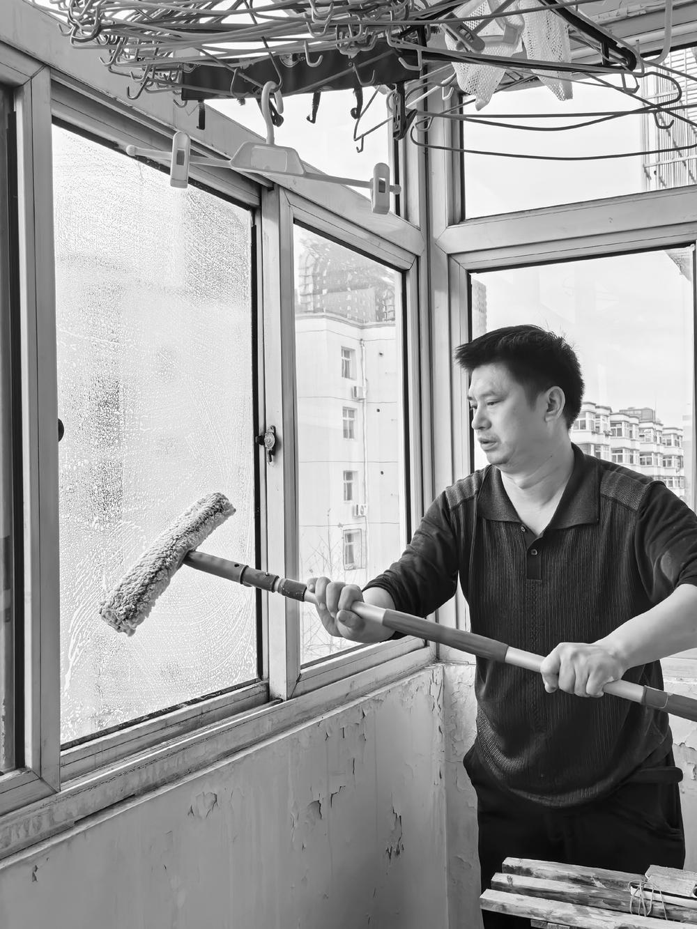 ▲图为家政服务人员在为用户擦阳台玻璃。