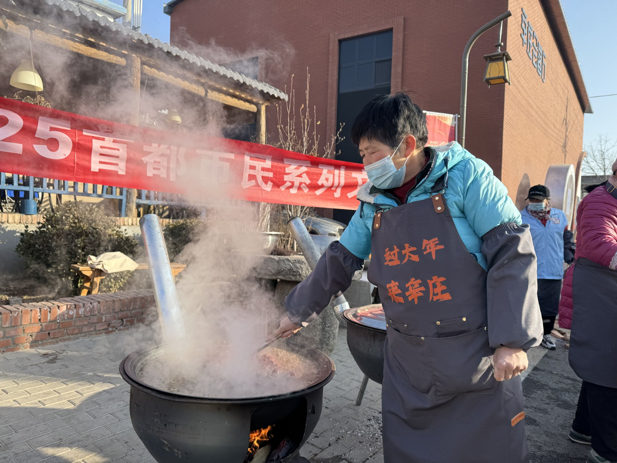 辛莊村創客街區，村民正在熬製臘八粥，免費提供給遊客。新京報記者 葉紅梅 攝