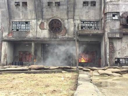 电影《八佰》拍摄现场的幕后花絮中，日军发起进攻，却被关在门内遭到反击