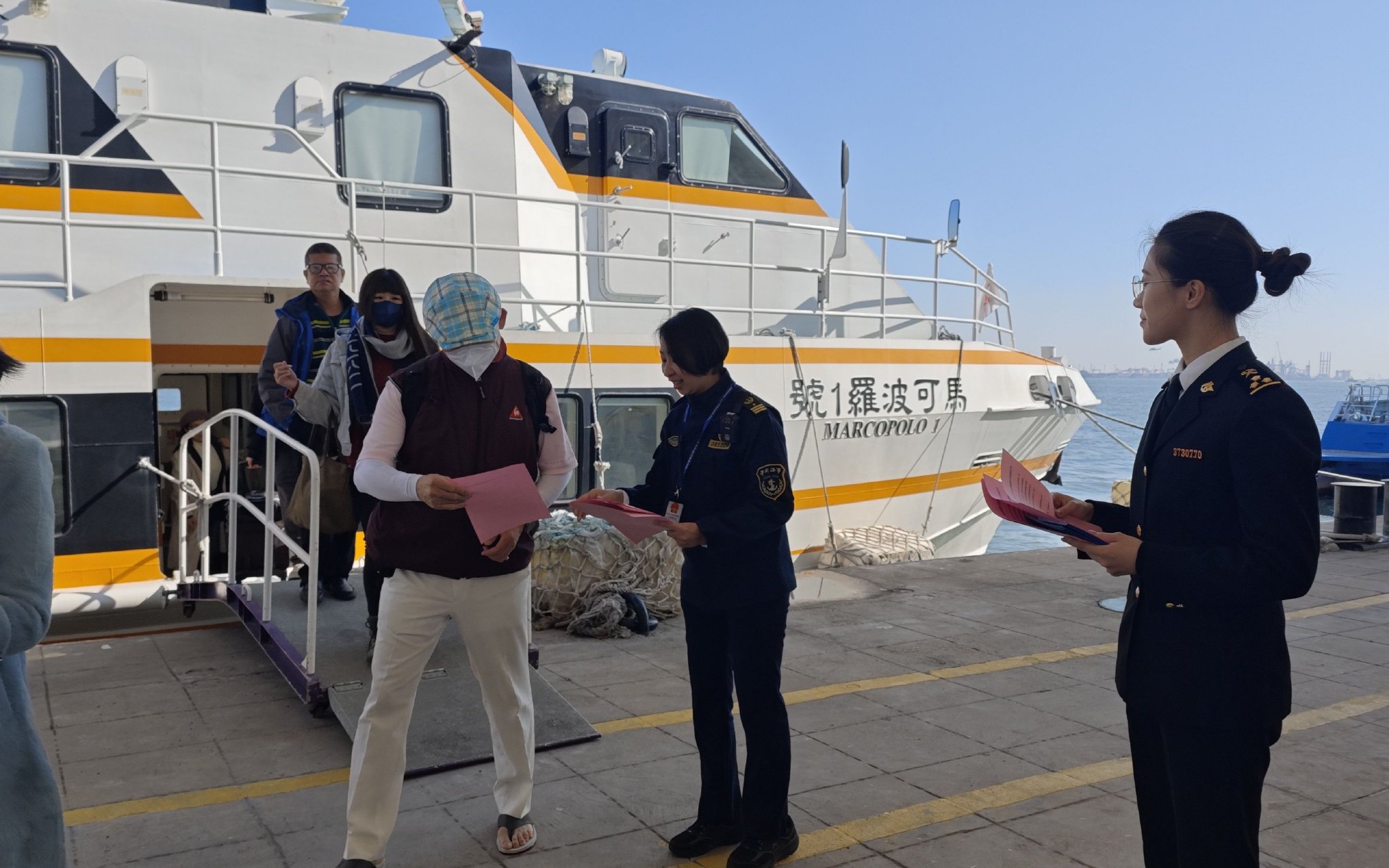 聯合執法隊員向旅客發放宣傳手冊，開展安全引導和登船檢查。 受訪者供圖