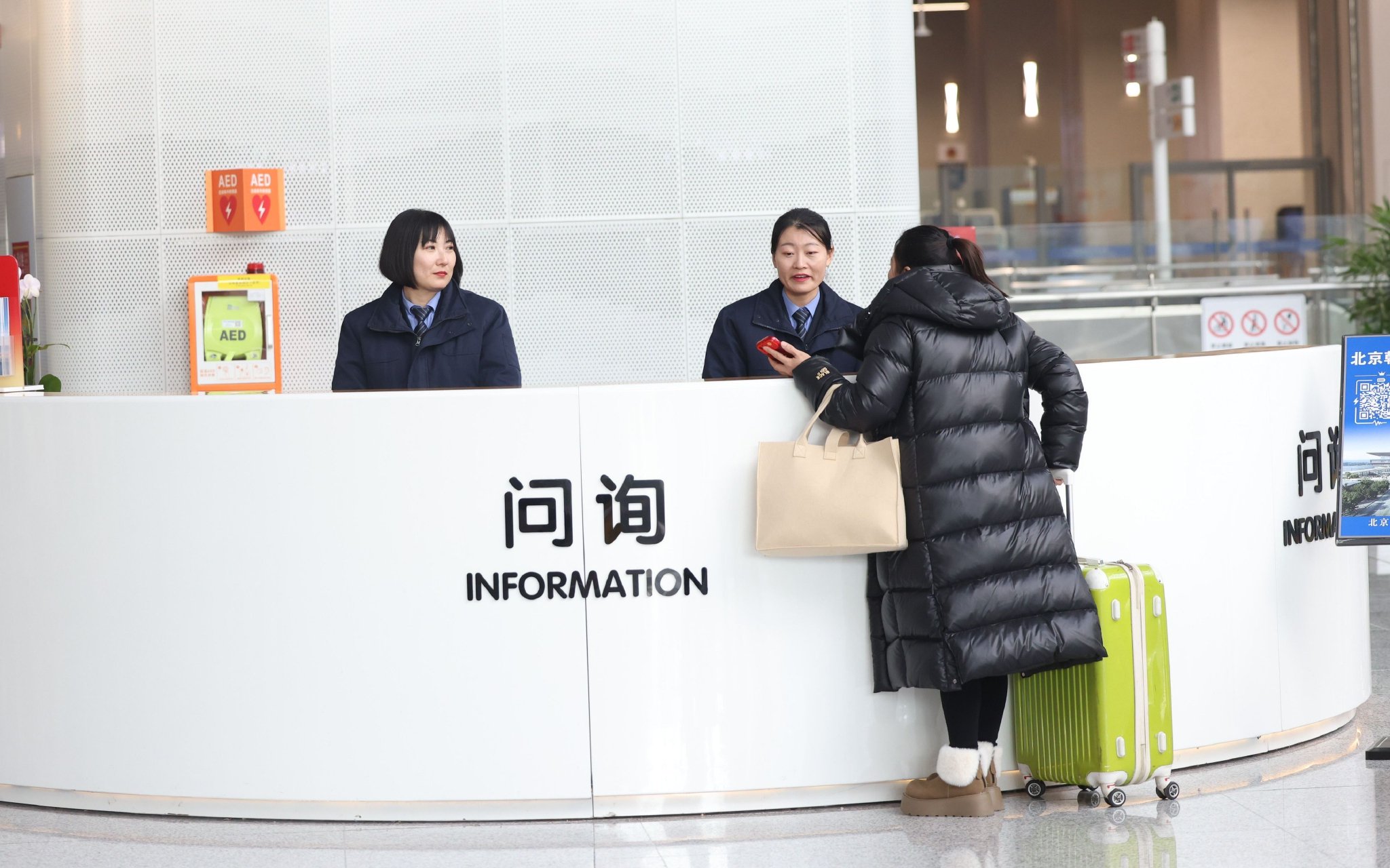 1月20日，北京朝陽站交通樞紐內，正選集團公聯樞紐公司工作人員在提供問詢服務。新京報記者 王貴彬 攝