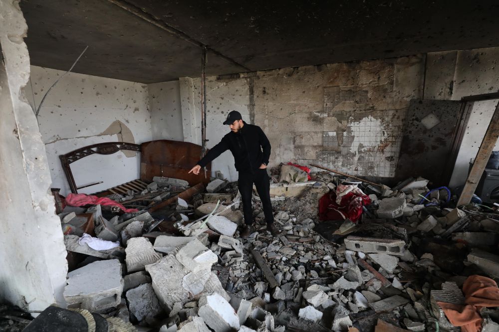 1月16日，在約旦河西岸傑寧難民營，巴勒史丹人查看遭以軍空襲的建築物廢墟。新華社發（尼達爾·艾仕塔耶攝）