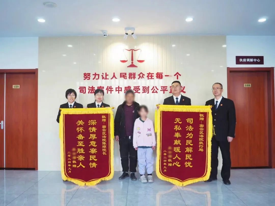 老胡和女兒小胡為密雲法院送來錦旗。圖源：密雲法院