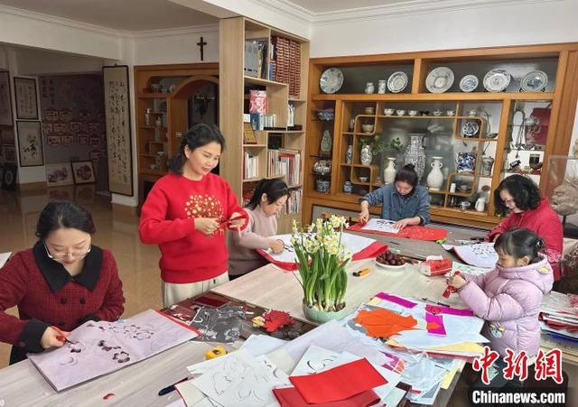2月4日,剪纸艺术家高少萍(左二)和徒弟们在福建省漳州市高少萍剪纸艺术馆创作剪纸作品。高少萍 供图