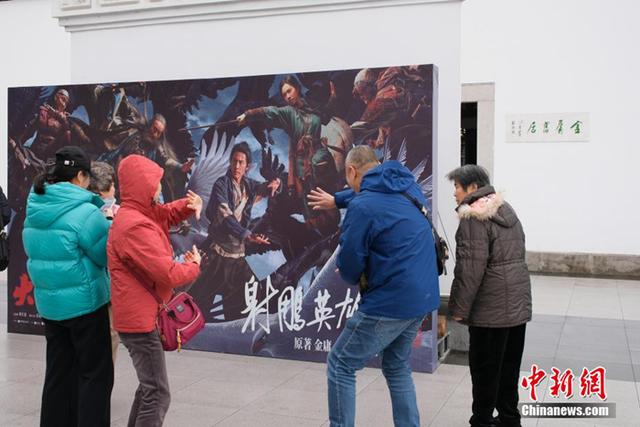 2月1日，游客在金庸故居前比划武侠招式。中新社记者 曹丹 摄