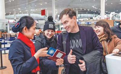 青岛机场工作人员热情接待外国旅客。青岛机场集团供图