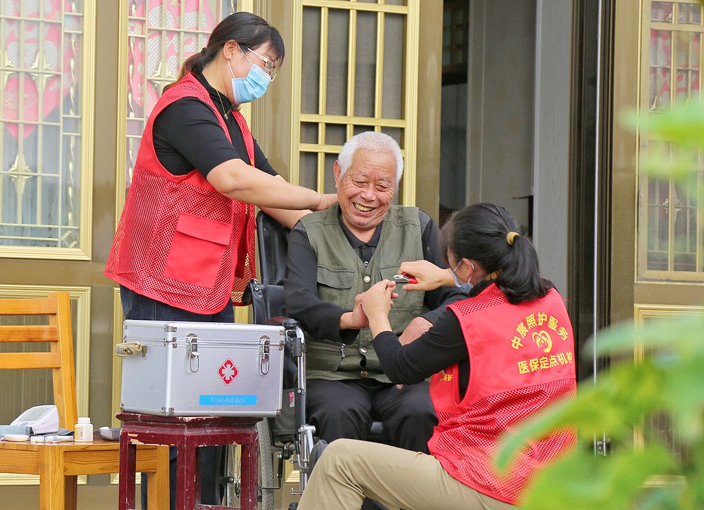 2023年10月11日,江苏南通,海安市墩头镇千步村,居家养老护理员上门为老人剪指甲。视觉中国 资料图