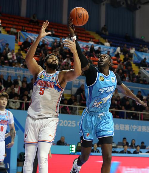 　　3月5日，宁波町渥队球员马帝昂（右）在比赛中与新疆伊力特队球员劳森（左）争抢篮板球。新华社发（索向鲁摄）