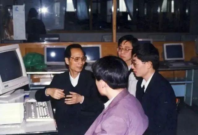 2006年，张钹院士（左一）与博士生在实验室讨论，图片来自清华大学公众号