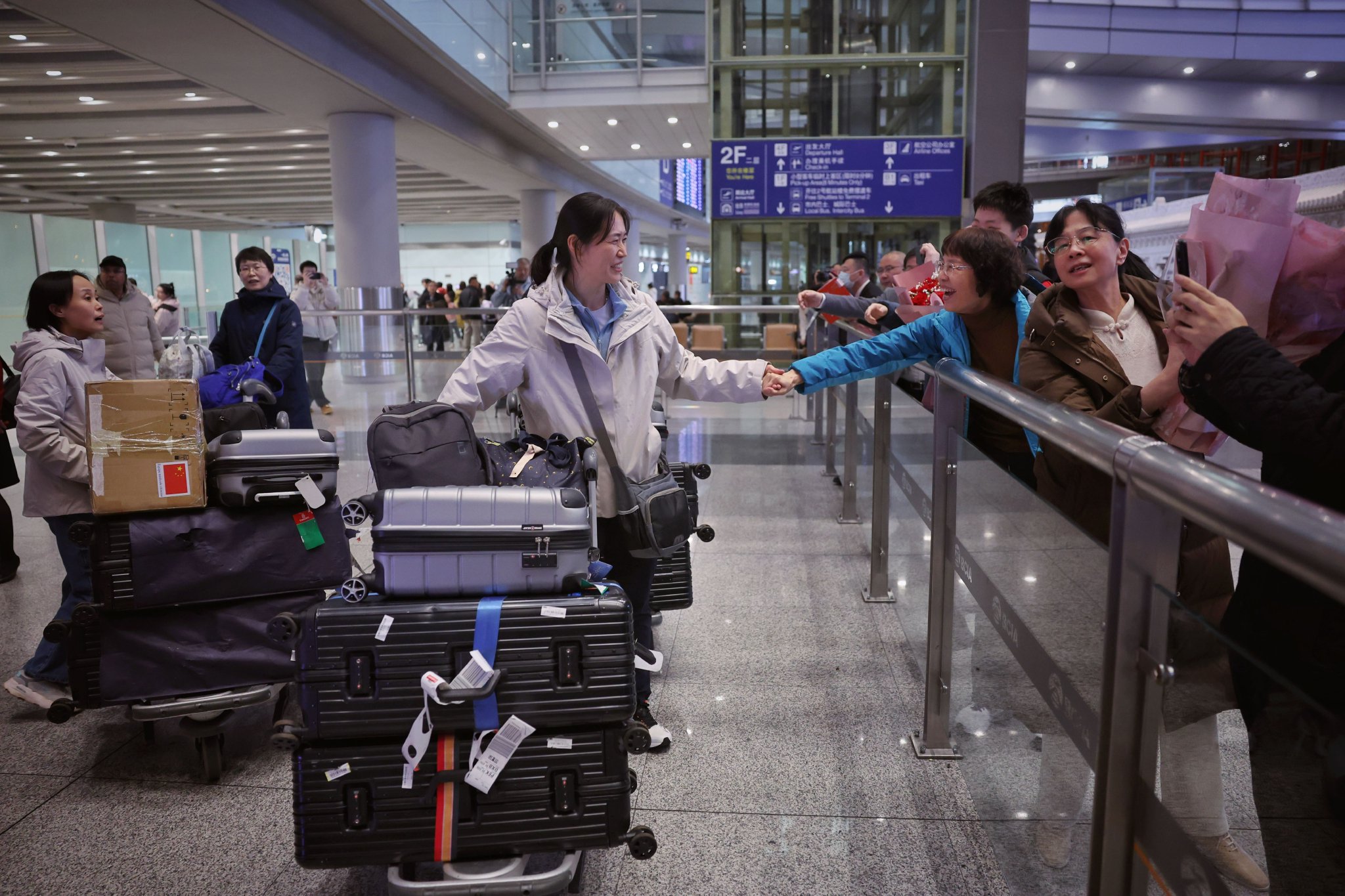 3月15日晚,首都國際機場T3航站樓,第30批援幾內亞中國醫療隊回到北京,受到親友和同事的熱烈歡迎。新京報記者 薛珺 攝