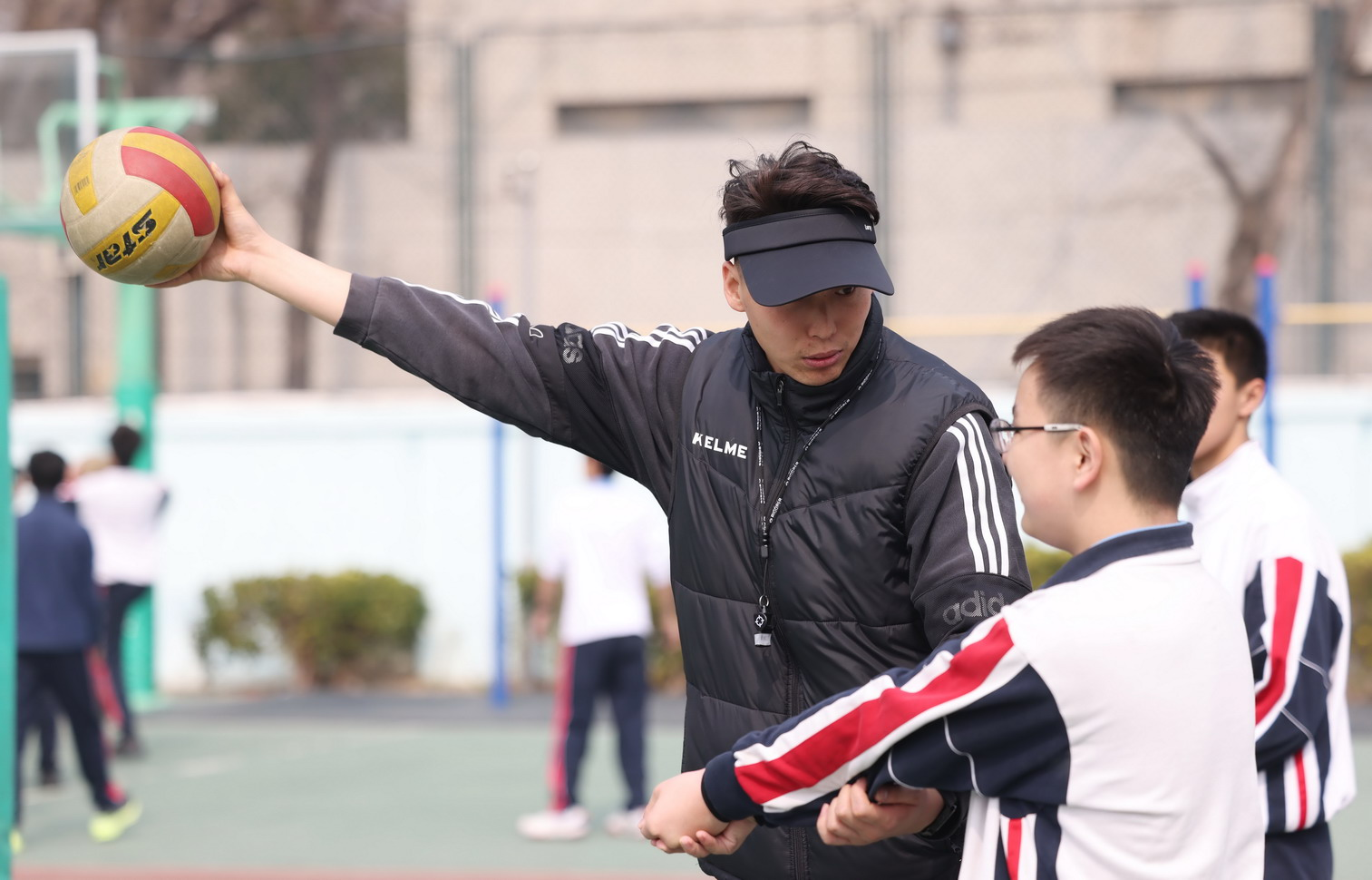 3月10日上午,東直門中學操場,排球課上,體育教師霍帥在輔導學生墊球練習。新京報記者 李木易 攝