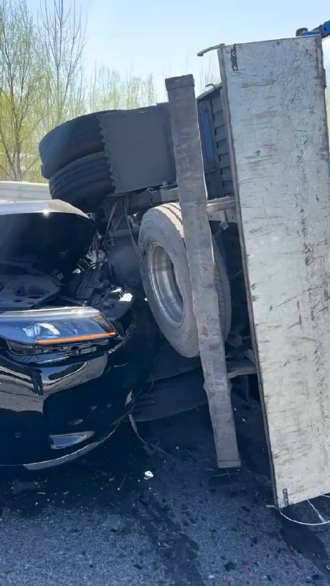 问界M7撞上满载木头货车 车主毫发无伤：淡定与车合影！