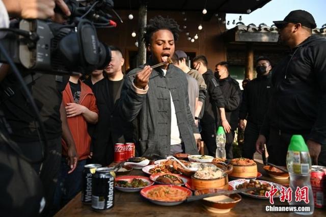 “甲亢哥”在重庆下浩里老街品尝皮蛋。中新社记者 何蓬磊 摄