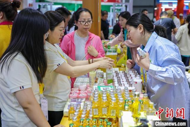 4月14日,海南海口,泰国企业展出的特色商品吸引参观者选购。中新社记者 骆云飞 摄